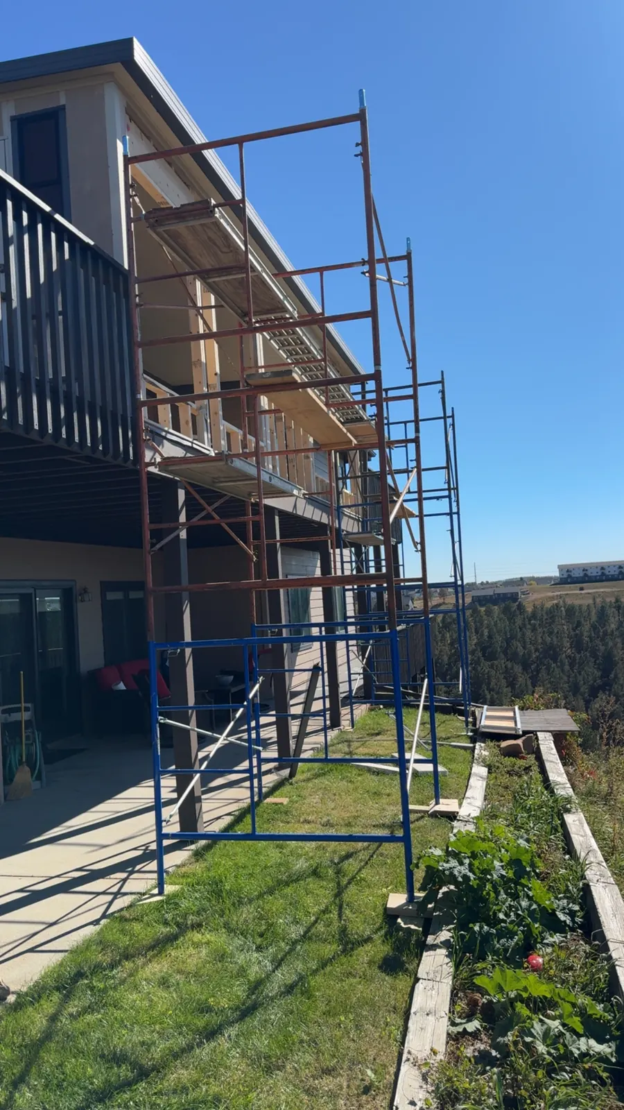 Exterior finish work on scaffolding at a two-story Black Hills home
