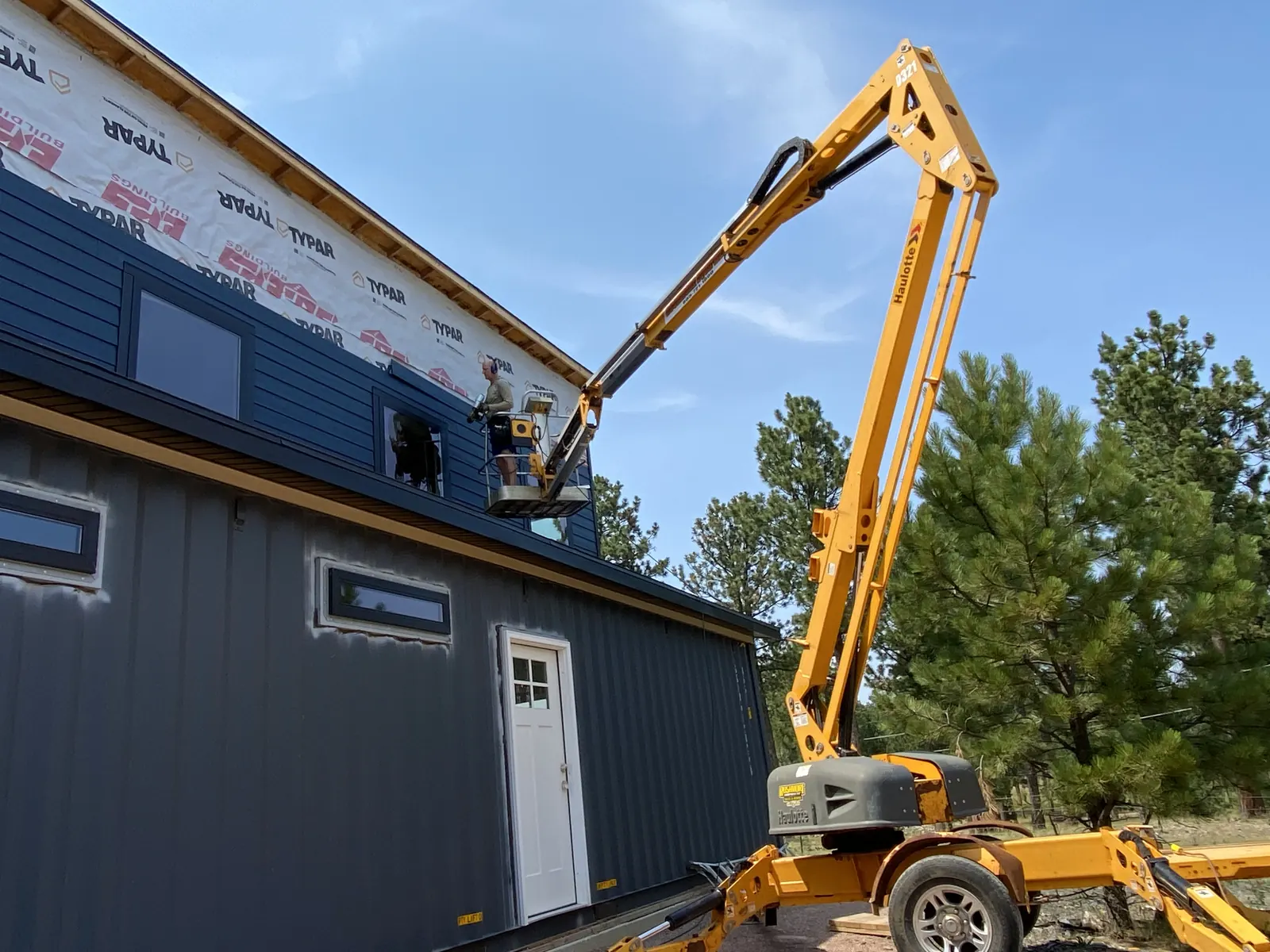 Custom shipping container building getting siding installed in the Black Hills