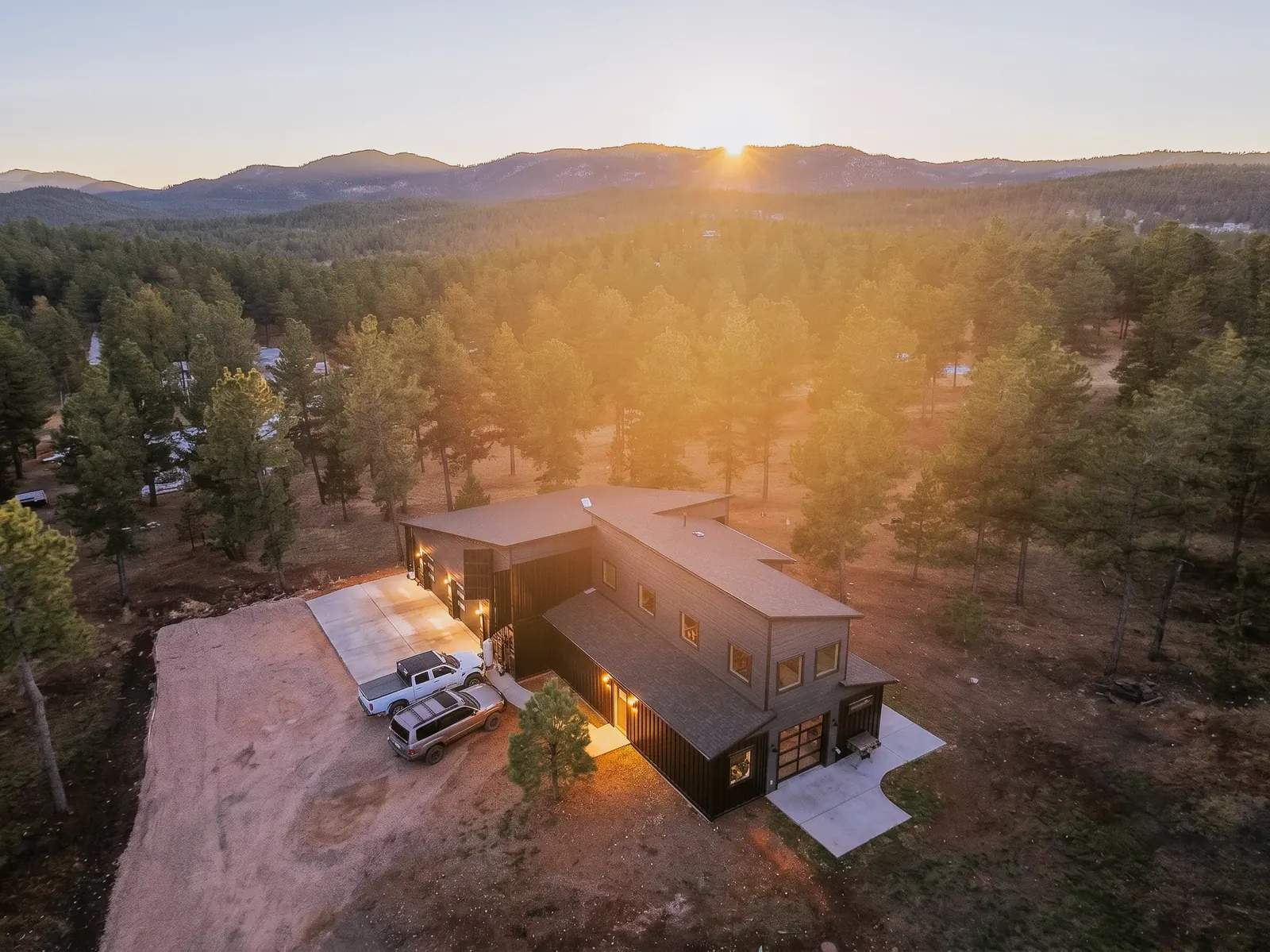 Custom modern home on an acreage in the Black Hills pines at golden hour, built by Black Hills Property Solutions
